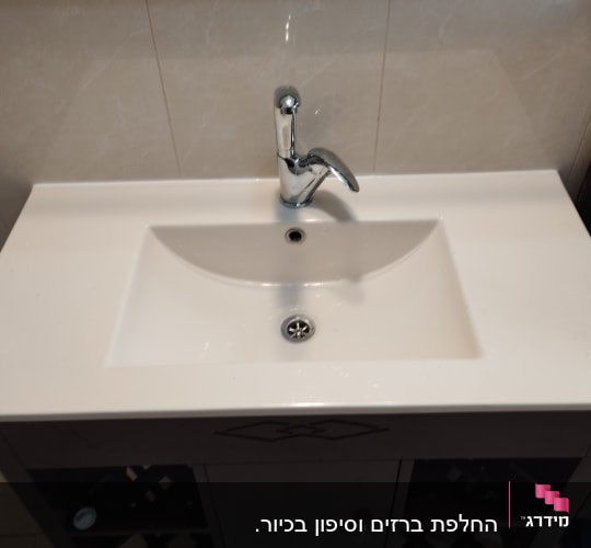 כיור עם ברז כרום ומגבות בצד